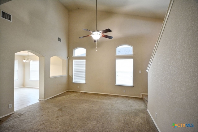 unfurnished living room with high vaulted ceiling, light colored carpet, and ceiling fan