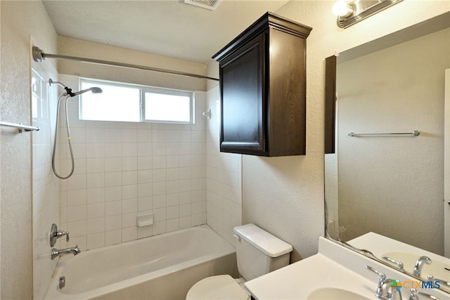 full bathroom with toilet, vanity, and tiled shower / bath