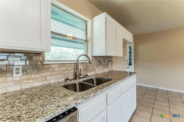 kitchen featuring backsplash, white cabinets, sink, light stone countertops, and light tile patterned flooring