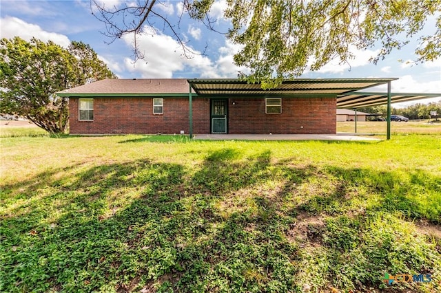 back of house with a yard and a carport