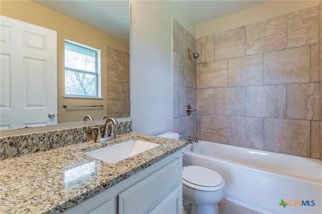 full bathroom with vanity, tiled shower / bath combo, and toilet