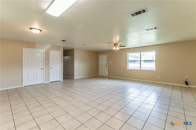 unfurnished room featuring ceiling fan, light tile patterned flooring, and a textured ceiling