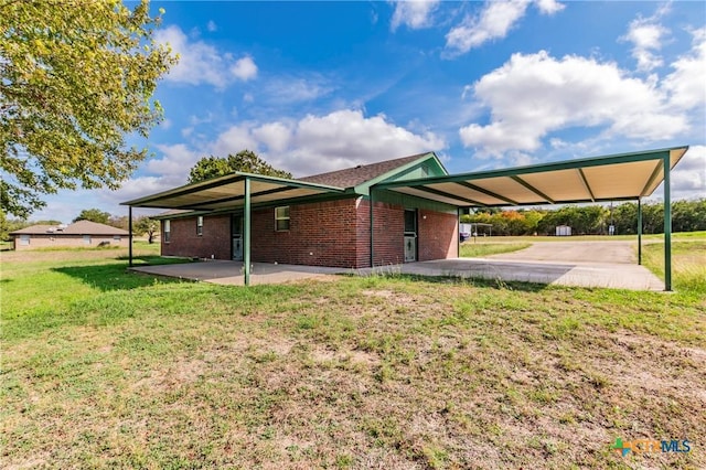 back of house with a carport and a yard