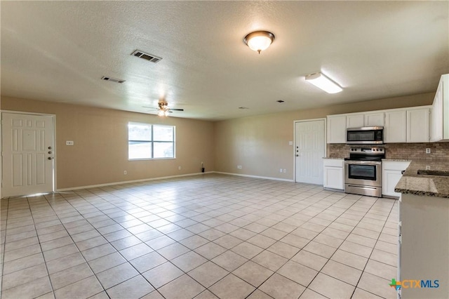 kitchen featuring stainless steel appliances, white cabinetry, tasteful backsplash, and light tile patterned flooring