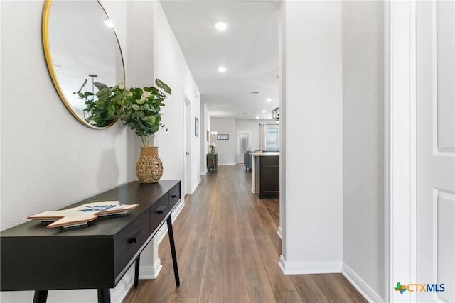 hall featuring recessed lighting, baseboards, and wood finished floors