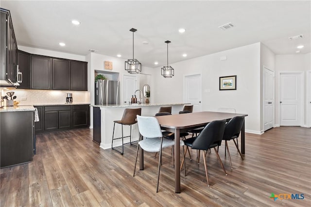 dining space featuring wood finished floors, visible vents, and recessed lighting