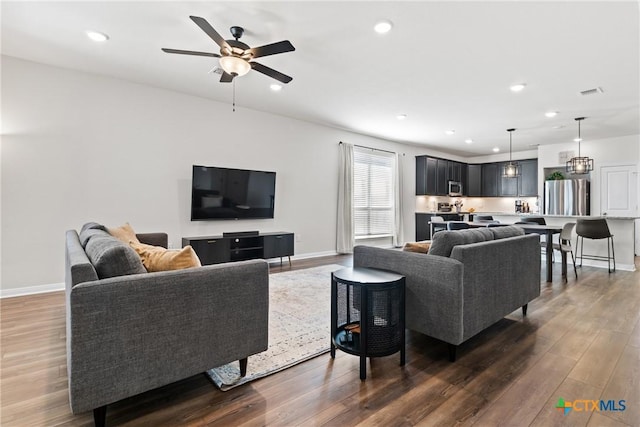 living area with dark wood-style flooring, recessed lighting, visible vents, ceiling fan, and baseboards