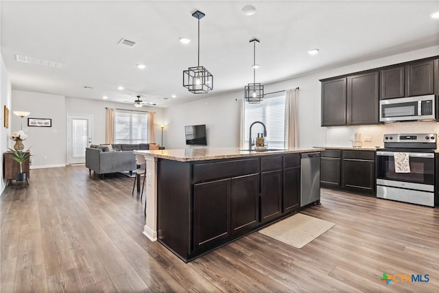 kitchen with stainless steel appliances, open floor plan, a healthy amount of sunlight, and a sink