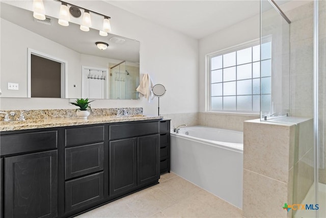 full bathroom with double vanity, a garden tub, tile patterned flooring, a shower stall, and a sink