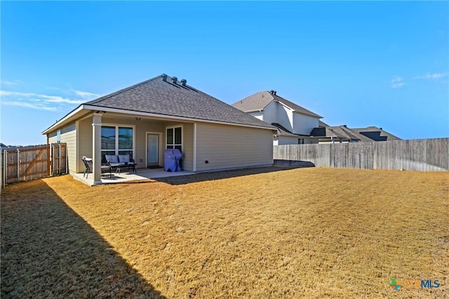 back of property featuring a yard, a fenced backyard, a patio, and a shingled roof