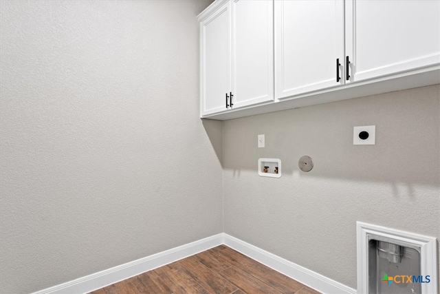 clothes washing area featuring cabinets, washer hookup, hookup for an electric dryer, dark hardwood / wood-style floors, and hookup for a gas dryer