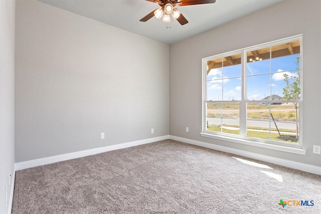 carpeted spare room featuring ceiling fan