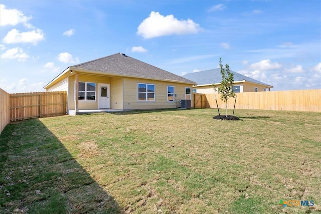 back of property featuring a yard and central AC