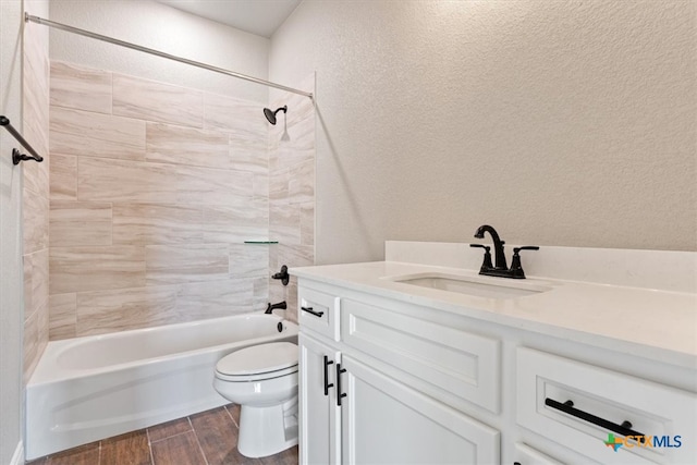 full bathroom with hardwood / wood-style flooring, toilet, vanity, and tiled shower / bath