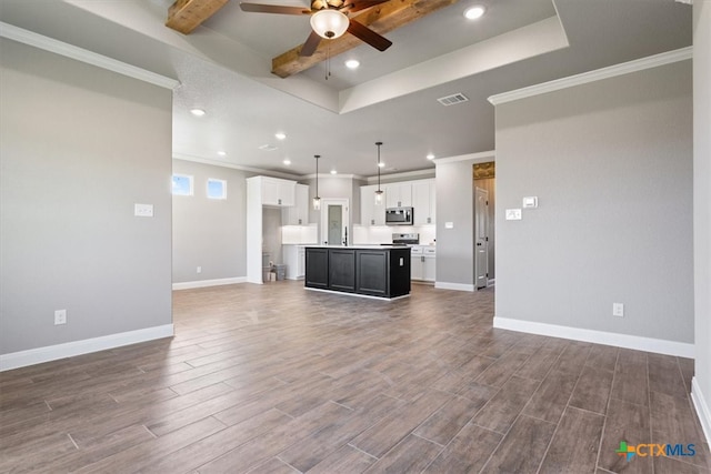 unfurnished living room featuring a raised ceiling, ceiling fan, crown molding, and dark wood-type flooring