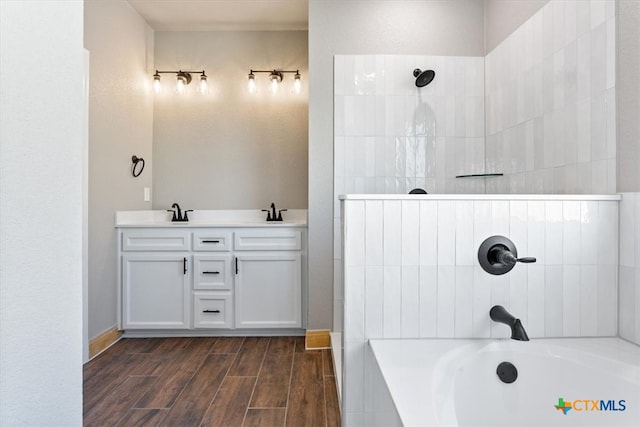 bathroom featuring wood-type flooring, vanity, and a tub