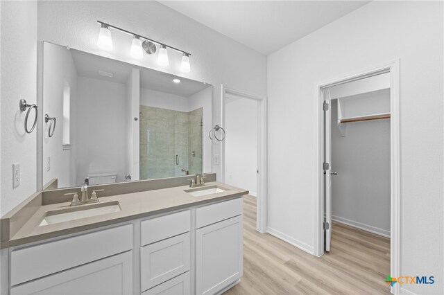 bathroom featuring hardwood / wood-style floors, vanity, toilet, and an enclosed shower