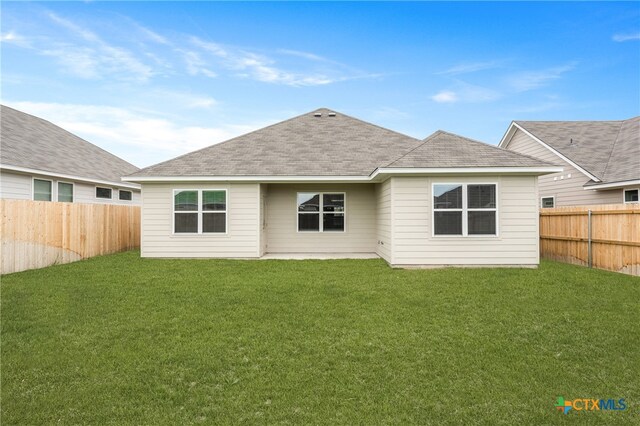 rear view of house featuring a lawn