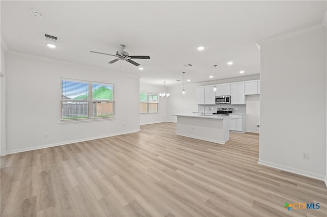611 Killam Dr, Temple, TX 76502 - unfurnished living room featuring light wood-type flooring, sink, ceiling fan with notable chandelier, and crown molding