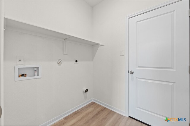 washroom with light wood-type flooring, electric dryer hookup, hookup for a gas dryer, and washer hookup