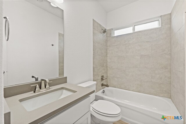 full bathroom with vanity, toilet, and tiled shower / bath combo