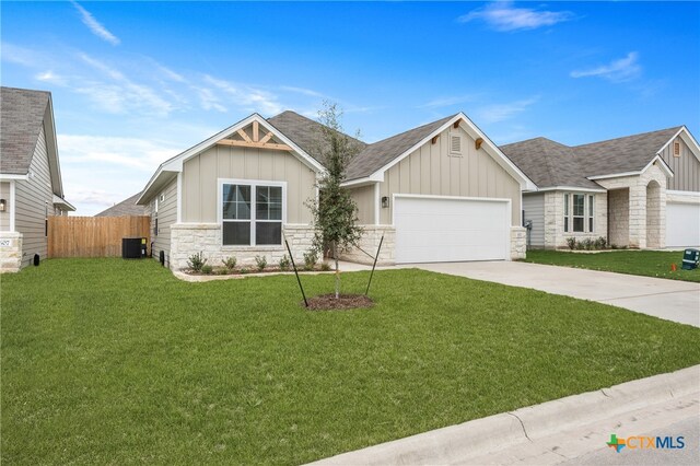 craftsman inspired home featuring a garage, a front lawn, and central AC