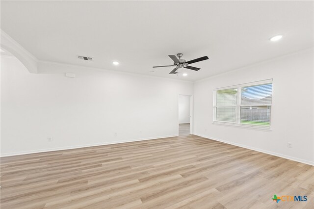 empty room with ceiling fan, light wood-type flooring, and ornamental molding