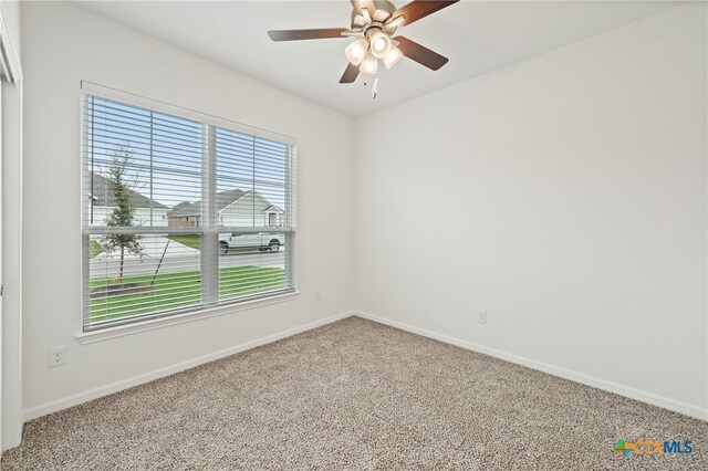 empty room with carpet, ceiling fan, and plenty of natural light