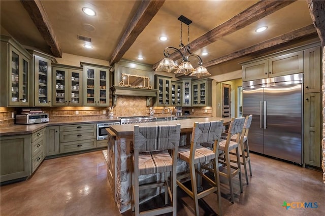 kitchen featuring pendant lighting, built in appliances, tasteful backsplash, a notable chandelier, and beam ceiling