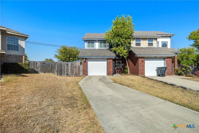 view of property featuring a garage and a front lawn