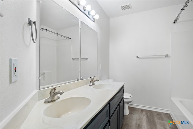 bathroom with hardwood / wood-style flooring, vanity, and toilet