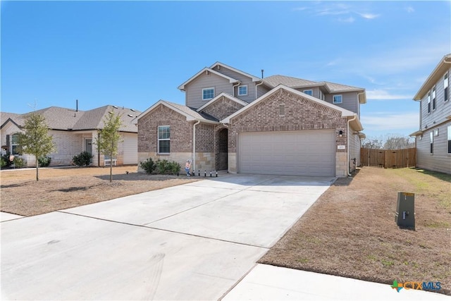 view of front of house with a garage, concrete driveway, stone siding, fence, and brick siding