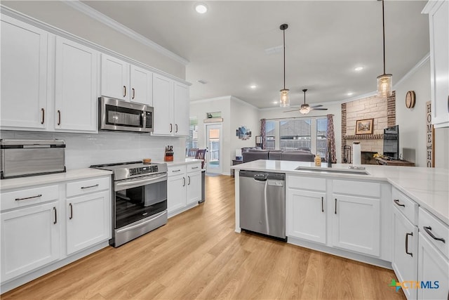 kitchen with white cabinets, appliances with stainless steel finishes, ceiling fan, and pendant lighting