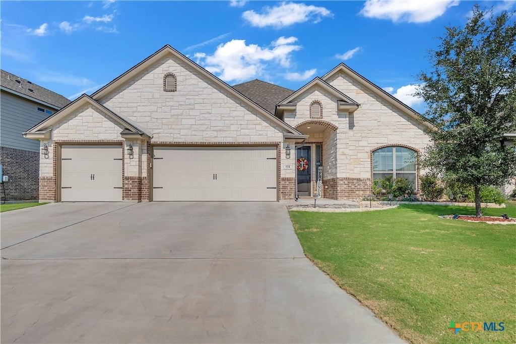 view of front of house with a garage and a front lawn