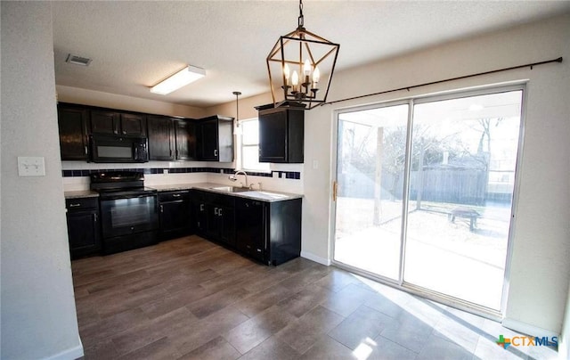 2705 Haven Dr, Killeen, TX 76543 - kitchen with black appliances, a chandelier, light countertops, pendant lighting, and dark cabinetry