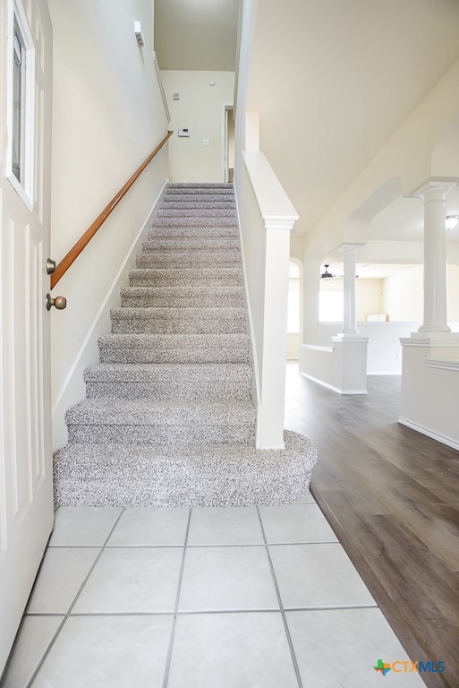 stairs with hardwood / wood-style floors and decorative columns