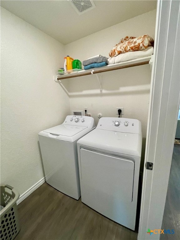 washroom with separate washer and dryer and dark hardwood / wood-style floors