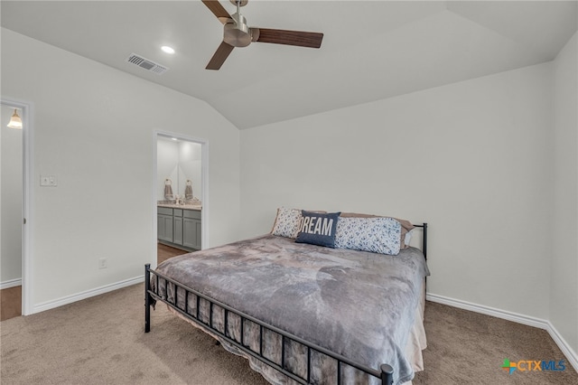 bedroom with ensuite bath, vaulted ceiling, light colored carpet, and ceiling fan