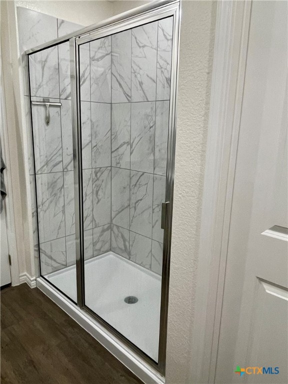 bathroom featuring walk in shower and wood-type flooring