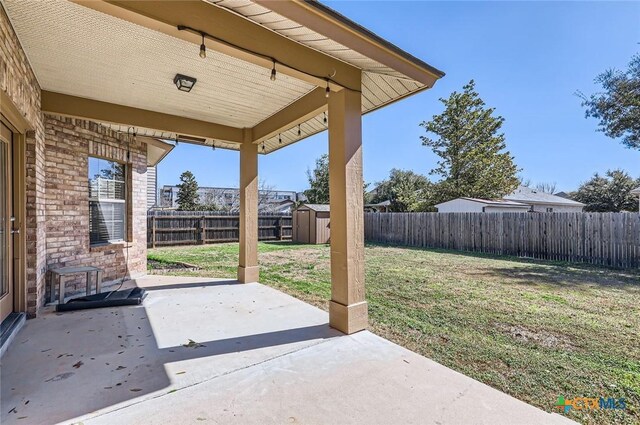 view of patio featuring a fenced backyard, an outdoor structure, and a shed