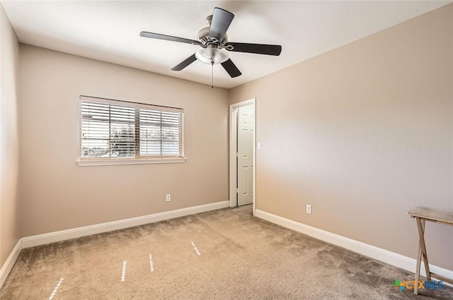carpeted empty room featuring a ceiling fan and baseboards