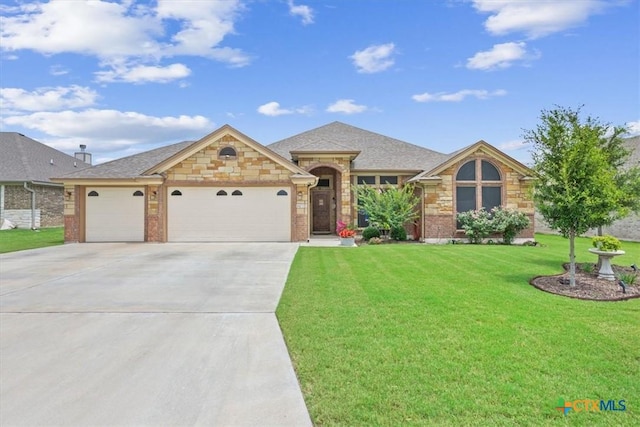 603 Willow Dr, Troy, TX 76579 - view of front of property featuring concrete driveway, an attached garage, a front yard, and stone siding