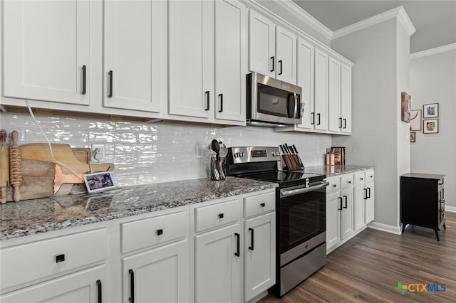 kitchen featuring dark wood-style flooring, stainless steel appliances, white cabinets, crown molding, and backsplash