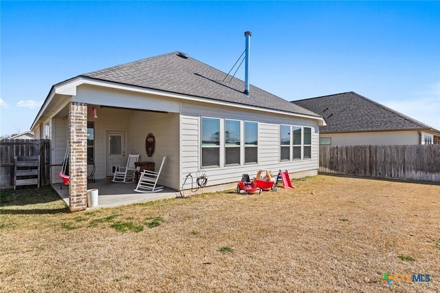 back of house featuring a patio area, a yard, and a fenced backyard