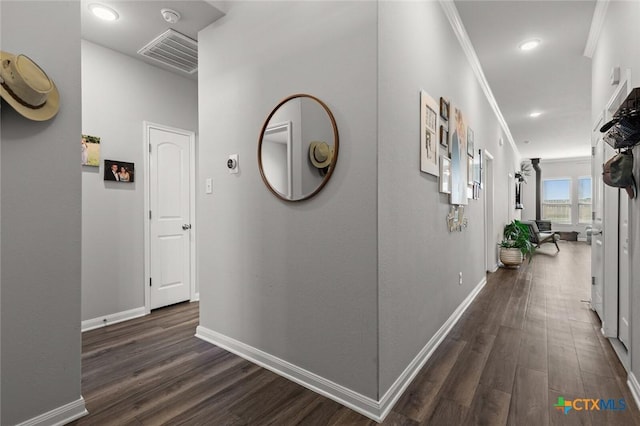 hallway featuring visible vents, baseboards, dark wood-style floors, and ornamental molding