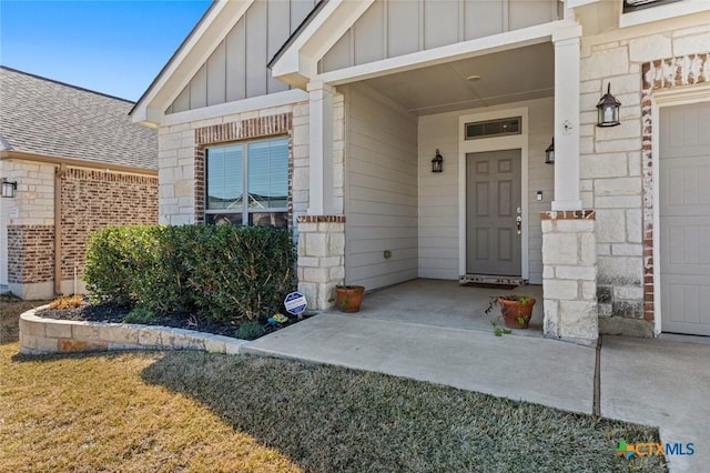 view of exterior entry with brick siding and board and batten siding