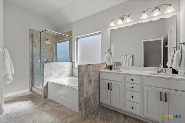 bathroom featuring double vanity, a stall shower, a garden tub, and a sink