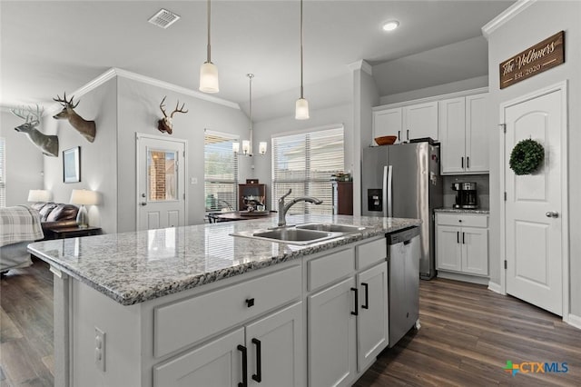 kitchen with visible vents, a kitchen island with sink, a sink, open floor plan, and appliances with stainless steel finishes