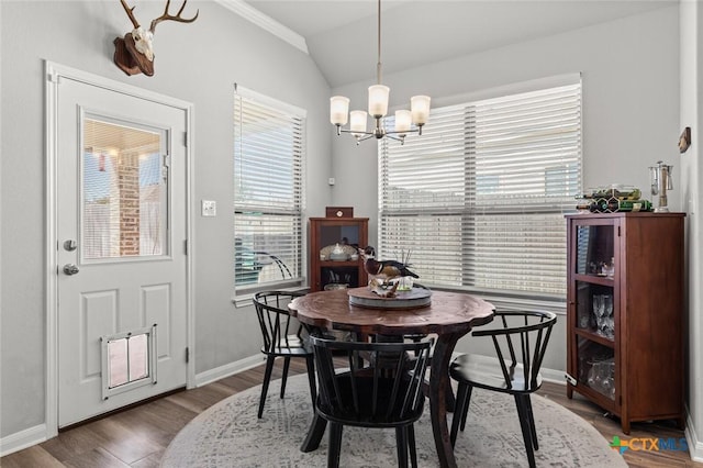 dining space with a chandelier, baseboards, lofted ceiling, and wood finished floors