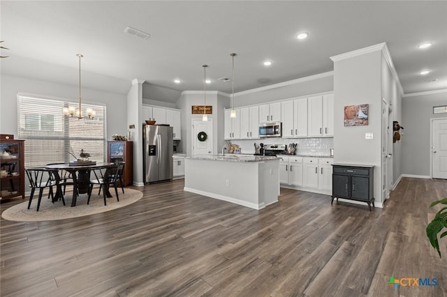 kitchen with visible vents, dark wood-style flooring, stainless steel appliances, decorative backsplash, and white cabinets